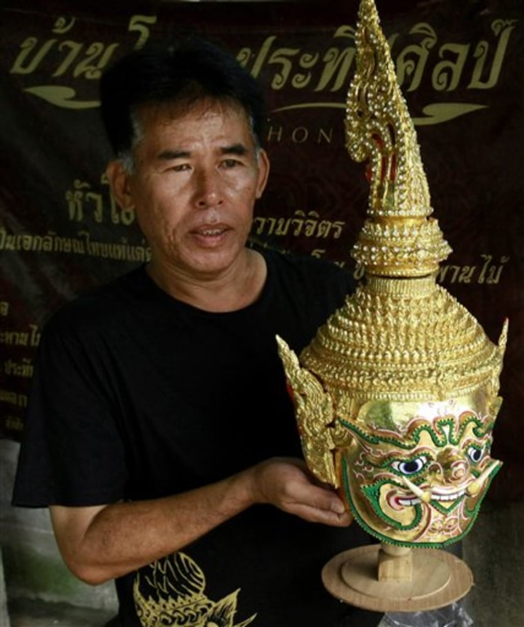 Prateep Rodpai, one of Thailand's last traditional Khon mask makers,  holds a Khon mask Aug. 8 at his home in Bangkok, Thailand. These types of masks are the keystones of ornate glittering costumes used in the stylized classical Thai dance form known as Khon. 